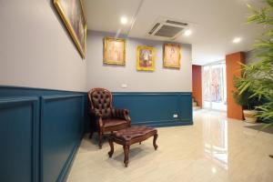 a waiting room with a leather chair and a chair at Super OYO 484 Pannee Residence Khaosan Sha Plus in Bangkok