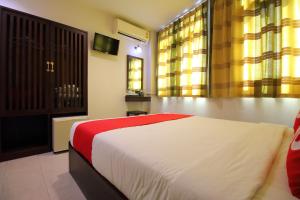 1 dormitorio con 1 cama con manta roja y blanca en Super OYO 484 Pannee Residence Khaosan Sha Plus, en Bangkok