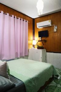 a bedroom with a bed and a pink curtain at Small Guest House Koh Kood in Ko Kood