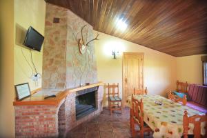 a living room with a fireplace and a table and a room with a table at Cortijo El Lerele in Cazorla