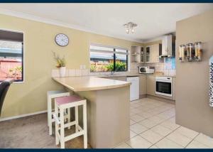 a kitchen with a counter and a clock on the wall at Sweet Home in Rotorua