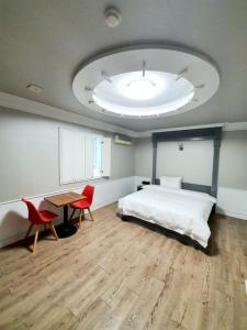 - une chambre avec un lit, une table et des chaises dans l'établissement Hill Motel, à Gyeongju