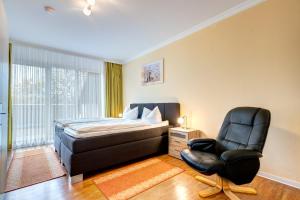 a bedroom with a bed and a chair at Am Schloonsee Haus D in Heringsdorf