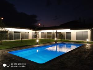 a swimming pool in the yard of a house at night at Carballos Altos-Apartamentos Turísticos in Arzúa
