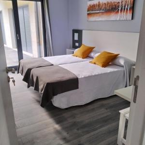 A bed or beds in a room at Carballos Altos-Apartamentos Turísticos