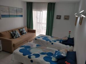 a living room with two beds and a couch at El Dorado Apartment Playa de Las Americas in Arona