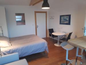 - une chambre avec un lit, une table et des chaises dans l'établissement loft studio avec charme et authenticité, à Altkirch