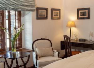 a bedroom with a desk and a chair and a table at Le Colonial 1506 - Exclusive Luxury Hideaway in Cochin