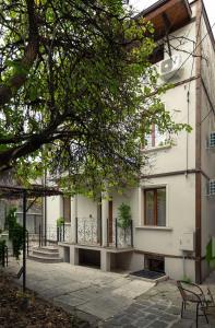 een wit gebouw met een veranda en een trap erop bij The White House Sofia in Sofia