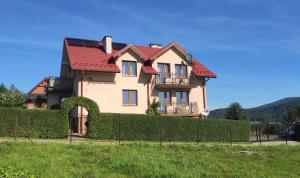 a large house with a red roof at Pokoje Panorama in Wysowa-Zdrój