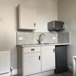 a kitchen with a sink and a microwave at Beechwood Garden Suite in Newtownabbey