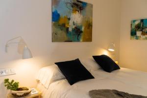 a bedroom with a white bed and a painting on the wall at Airoto by Totiaran in Baqueira-Beret