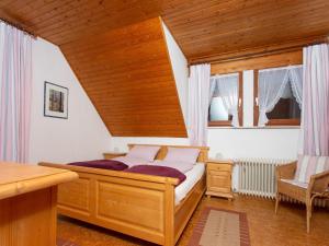 a bedroom with a bed with a wooden ceiling at Bartleshof in Wolfach