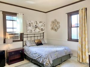 a bedroom with a bed and two windows at Spring Creek Hotel in Hot Springs