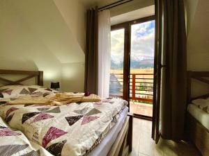 a bedroom with a bed and a window with a view at Villa Jarka Rent in Ždiar