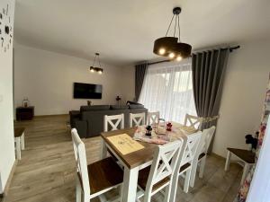 a dining room and living room with a table and chairs at Villa Jarka Rent in Ždiar +27 photos