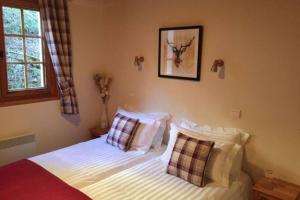 a bedroom with a bed with white sheets and pillows at Chalet Les Erines in Châtel