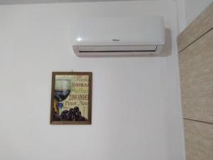 eine an der Wand montierte Klimaanlage in einem Zimmer mit einem Bild in der Unterkunft Canto da Praia in Itajubá