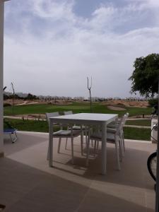 羅爾丹的住宿－Las Terrazas Golf Resort Rental，庭院里摆放着白色的桌椅