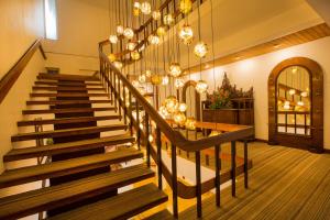 a staircase in a building with a chandelier at Casino Hotel - CGH Earth, Cochin in Cochin