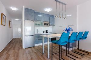uma cozinha com cadeiras azuis, uma mesa e um frigorífico em Amazing view FREE WIFI em Callao Salvaje