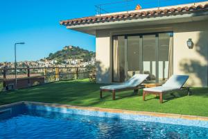 een huis met 2 stoelen en een zwembad bij Nou Sol Solet in Begur