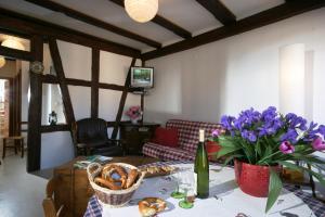 uma sala de estar com uma mesa com flores roxas em Apart' City Break Colmar em Colmar