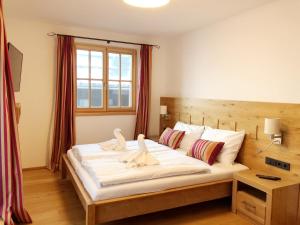 um quarto com uma cama com dois cisnes em The LODGE, Saalbach em Saalbach-Hinterglemm