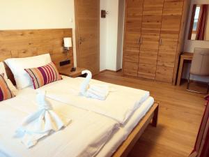 a bedroom with a large white bed with swans on it at The LODGE, Saalbach in Saalbach-Hinterglemm