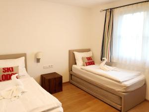 um quarto com 2 camas e uma janela em The LODGE, Saalbach em Saalbach-Hinterglemm