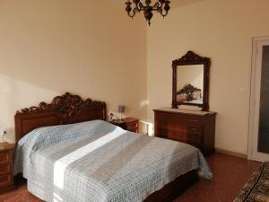 - une chambre avec un lit, un miroir et une commode dans l'établissement Appartamento Beatrice, à Pistoia