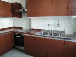 a kitchen with wooden cabinets and a sink at Appartamento Beatrice in Pistoia +7 photos