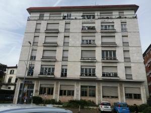 a tall building with cars parked in front of it at Appartamento Beatrice in Pistoia