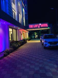 um parque de estacionamento em frente a um hotel à noite em The Loft Hotel, Siliguri em Siliguri