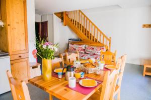 una mesa de madera con comida en la cocina en Résidence Plein Soleil, en Avrieux