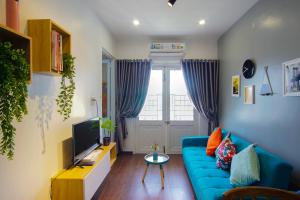 a living room with a blue couch and a tv at KIRAKUAN LUXURY 2 BR, 5m Center in Thôn Trường Giang