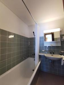 ein Badezimmer mit einer Badewanne, einem Waschbecken und einer Badewanne in der Unterkunft Schnider Bed&Breakfast und Café in Vals