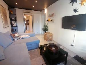 a living room with a blue couch and a flat screen tv at Via Corso in Rijeka