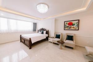 a bedroom with a bed and two chairs at Saigon Hanoi Central Hotel in Ho Chi Minh City
