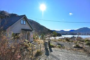 une maison sur une colline avec le soleil dans le ciel dans l'établissement tocoro. Mt. Fuji Mutsuki, à Fujikawaguchiko 47 autres photos