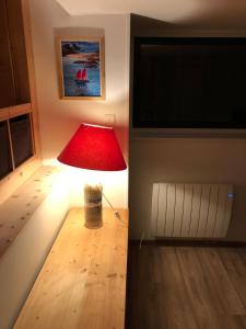 een rode lamp op een tafel in een kamer bij Gîte de Kereveur, Loguivy de la Mer in Ploubazlanec