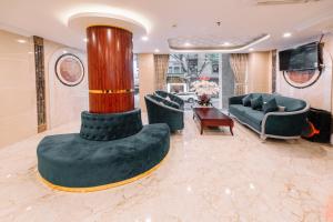 a living room with a column and couches and a television at Saigon Hanoi Central Hotel in Ho Chi Minh City