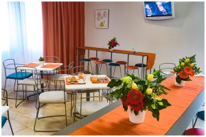 a dining room with tables and chairs and flowers at Santa Teresa House in Verona