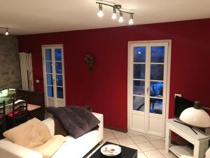 sala de estar con paredes rojas y sofá blanco en Casa Lidia, en Ossuccio