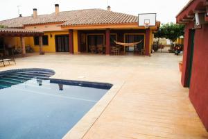 una piscina frente a una casa con un aro de baloncesto en casa ximo, en L'Aldea