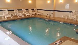 una gran piscina con sillas y una mesa en Springdale Inn & Suites Mobile-South Alabama University Area, en Mobile