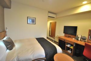 a hotel room with a bed and a flat screen tv at Hotel Mark-1 Tsukuba in Tsukuba