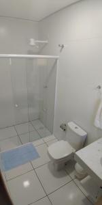 a white bathroom with a toilet and a shower at Residencial JL Maresias Apartamentos in Maresias +15 photos