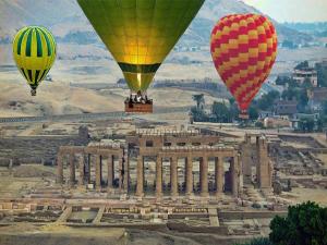 a group of hot air balloons flying over a city at Luxor Luxury Nile Cruises - From Luxor 04 & 07 Nights Each Saturday - From Aswan 03 & 07 Nights Each Wednesday in Luxor