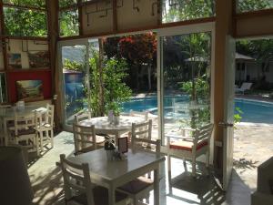 a patio with tables and chairs and a pool at Beach Hotel Casa Nina in Las Terrenas